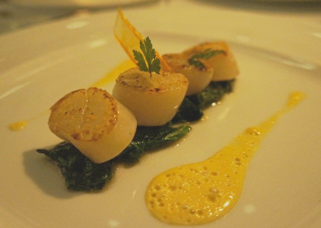 Seared scallops served on a bed of sauteed spinach and with saffron butter at Le Basilic (Mediterranean) restaurant in Cancun, Mexico