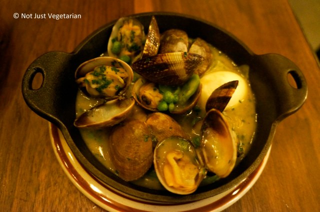 Clams cooked in salsa verde with parsley, asparagus and English peas at Barraca NYC