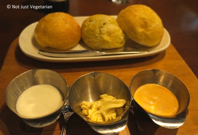 Freshly Baked bread (Left to Right, Onion, Jalapeno, and Plain), served with spreads (Left to Right: Garlic spread, coriander butter, and chipotle mayo), served at Fred's House Seafood Market & Grill in Cancun, Mexico