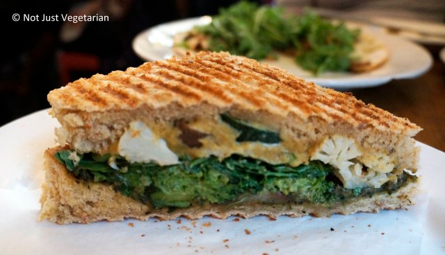 Vegan mediterranean oven-dried seasonal vegetable (Broccoli, cauliflower) Panini with cashew cheese and basil spinach pesto at Peacefood Cafe NYC