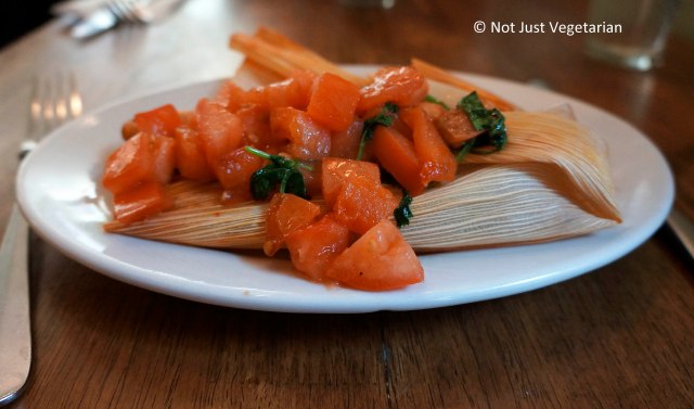 Vegan vegetable tamale with diced tomatoes and cilantro oil at Peacefood Cafe NYC