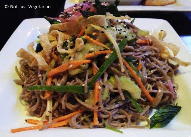 Buckwheat soba noodle salad with seasonal vegetables,crispy basil leaves, enoki mushrooms, and wonton crisps in a wasabi-soy vinaigrette at Brickyard Gastropub NYC