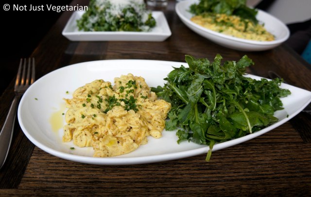 Two eggs scrambled with gruyere and fine herbs served with a side of greens at Tremont NYC