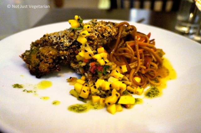 Aubergine Teriyaki (Char-grilled aubergine layered with coriander pesto, roasted red peppers, shitake mushrooms and horseradish, coated with crispy breadcrumbs and served on stir-fried noodles with a pickled ginger and mango salsa) at The Gate Islington in London