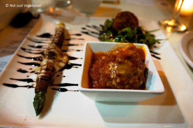 Left: Asparagus wrapped in speck, with fontina cheese and balsamic vinegar reduction, and Right: grass-fed beef meatball in tomato sauce at Giano NYC