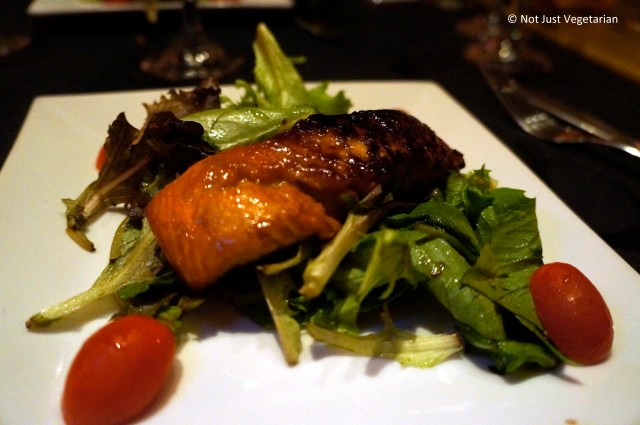 Asian marinated grilled salmon on a bed of mixed greeens at Masq restaurant and lounge, NYC